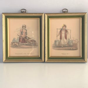 May include: Two framed antique prints depicting women selling goods. The left print shows a woman pushing a wheelbarrow full of potatoes with a dog by her side. The text below the image reads "Potatoes, full weight." The right print shows a woman carrying two buckets of milk on a yoke. The text below the image reads "Milk 01d."