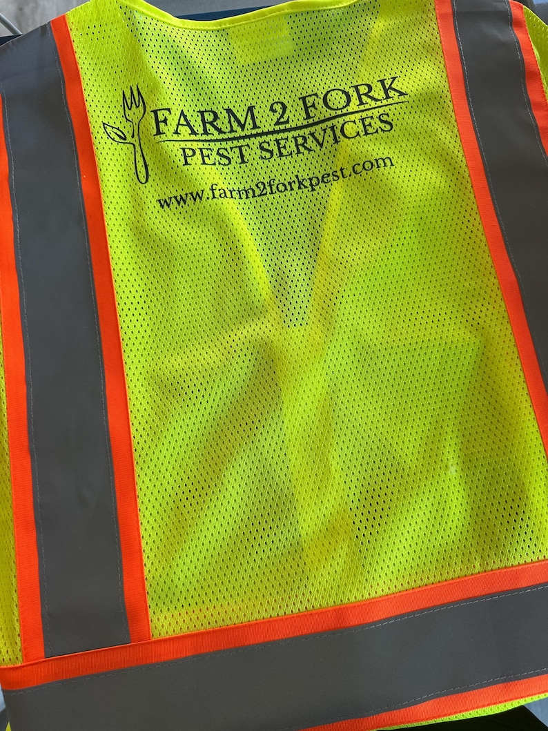 Op de afbeelding: Een neon-geel veiligheidsvest met hoge zichtbaarheid en verticale oranje en grijze reflecterende strepen. De achterkant toont een zwarte afbeelding van een vork gecombineerd met een blad, en de tekst FARM 2 FORK PEST SERVICES en www.farm2forkpest.com.