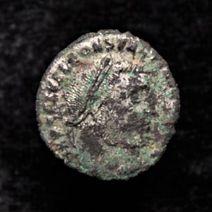 Op de afbeelding: Een Romeinse zilveren munt met een portret van een persoon op de ene kant. De munt is versleten en heeft een groene patina.