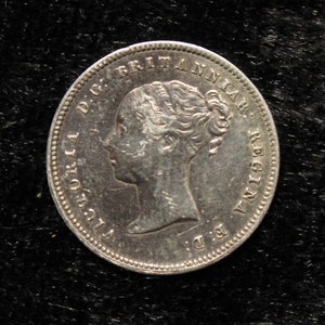 May include: Silver coin with a portrait of Queen Victoria on the obverse. The coin reads "Victoria D.G. Britanniar. Regina."
