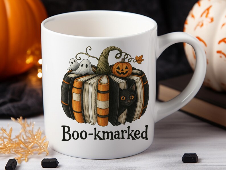 K&ouml;nnte beinhalten: Wei&szlig;e Keramiktasse mit einem Halloween-Design. Das Design zeigt einen K&uuml;rbis aus B&uuml;chern, einen K&uuml;rbis, Geister und eine schwarze Katze. Der Text "Boo-kmarked" ist auf der Vorderseite aufgedruckt.