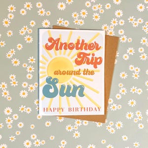 May include: A birthday card with a sun graphic and the text "Another Trip around the Sun Happy Birthday".