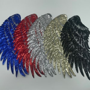 May include: Five embroidered wing-shaped patches featuring dense sequin embellishments in blue, red, silver, gold, and black. Each patch is constructed with a mesh backing and displays a detailed feather pattern arranged in a curved wing formation.
