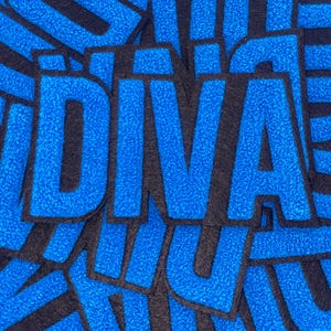 Puede incluir: Una pila de parches de fieltro azul y negro que deletrean la palabra "DIVA".