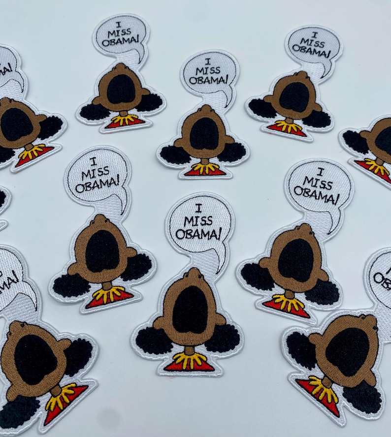 May include: A set of 10 iron-on patches featuring a cartoon character with the text "I Miss Obama!" in a speech bubble. The character is a brown-skinned person with black hair and a large open mouth.