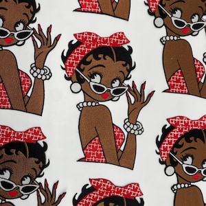 May include: Multiple embroidered patches featuring a cartoon character with black hair, a red headband with a white geometric pattern, white cat-eye sunglasses, a pearl necklace, a pearl bracelet, red fingernails, and a red patterned top.