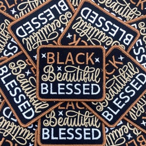 Peut inclure: Écussons carrés noirs brodés avec les mots "BLACK Beautiful BLESSED" en écriture blanche et dorée. Les écussons ont un fond noir avec une bordure dorée et de petits accents d'étoiles.