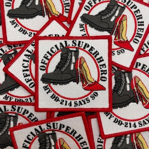 Puede incluir: Un montón de parches cuadrados con fondo blanco y borde rojo. Cada parche presenta una bota de combate negra y un tacón alto rojo, con el texto "OFFICIAL SUPERHERO" y "MY DD-214 SAYS SO" en un diseño circular.