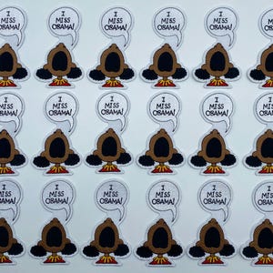 May include: Twenty-four white iron-on patches with a cartoon character and the text "I Miss Obama!" printed in black.