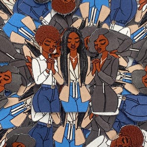 May include: Embroidered patches featuring illustrations of Black women in various outfits, including blazers, blouses, and jeans. The women are depicted with their hands clasped in prayer. The patches are in shades of blue, beige, gray, and brown.