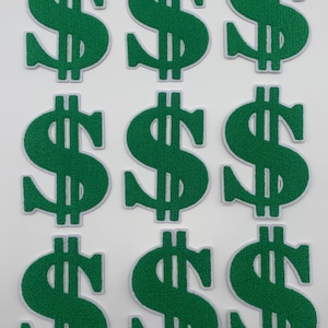 May include: Nine green felt iron-on patches in the shape of a dollar sign. Each patch has a white outline.