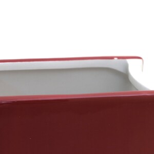 May include: A red ceramic planter with a white rim. The planter is empty and has a smooth, glossy finish.