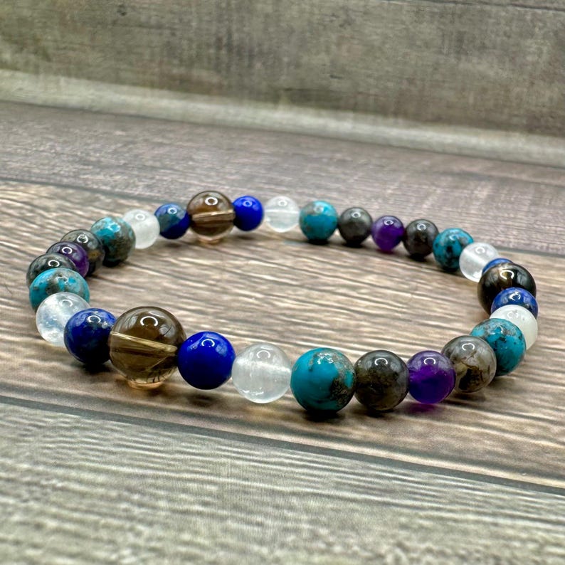 May include: A beaded bracelet featuring a range of gemstones, including turquoise, amethyst, lapis lazuli, and smoky quartz.