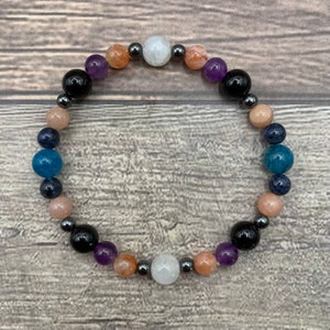 May include: A multi-colored beaded bracelet with blue, purple, orange, white, and black beads. The bracelet is made with natural stones and metal beads.