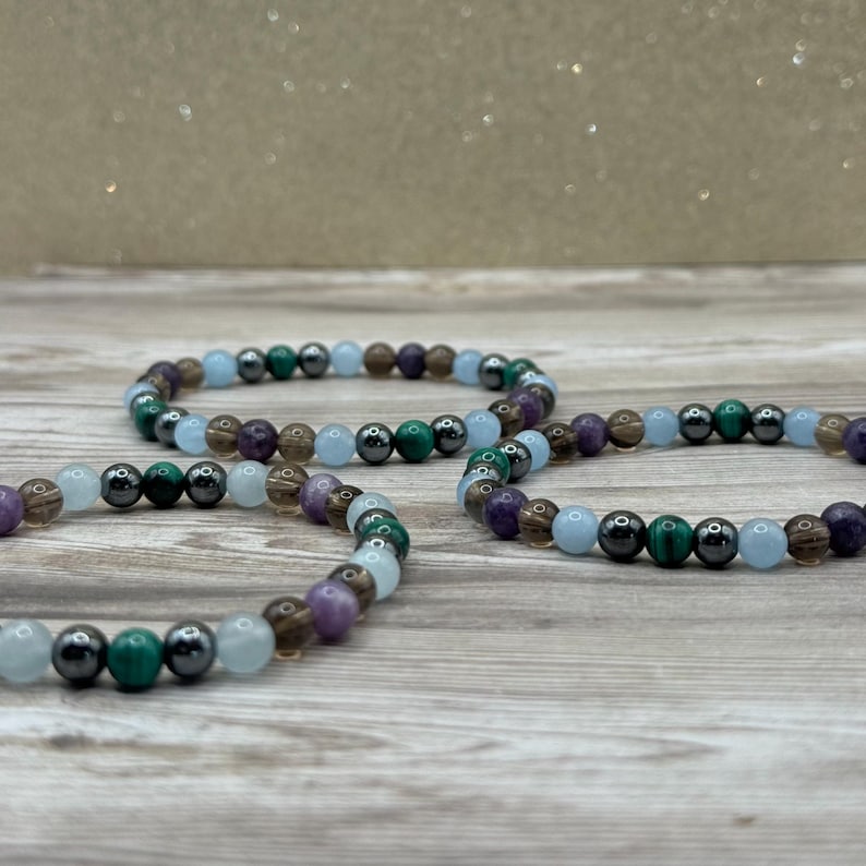 Pode incluir: Tr&ecirc;s pulseiras de contas com uma mistura de contas azuis, verdes, marrons e roxas. As pulseiras s&atilde;o feitas com pedras naturais.
