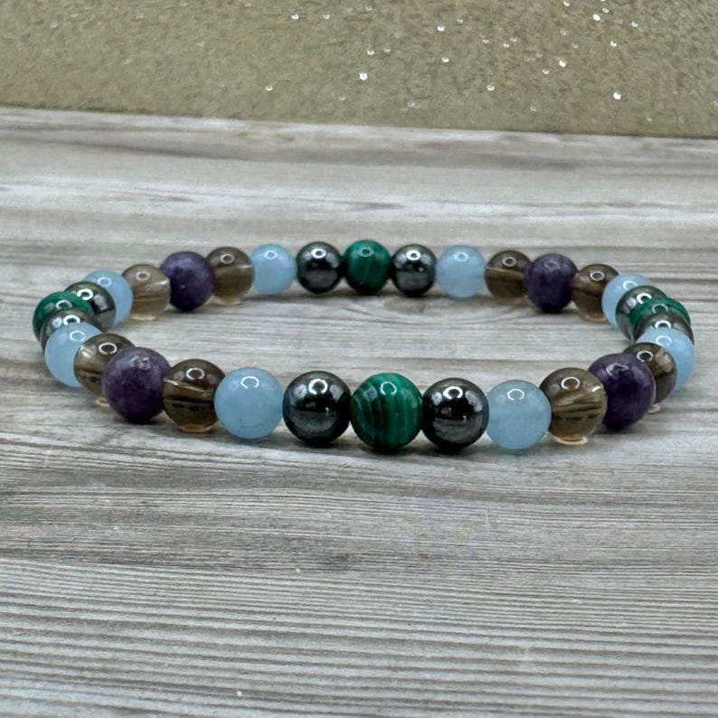 Pode incluir: Um bracelete de contas com contas alternadas de ametista, quartzo fumado, &aacute;gua-marinha, malaquita e hematita.
