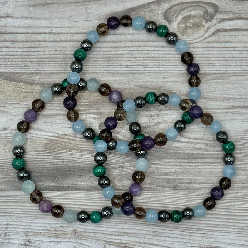 Pode incluir: Tr&ecirc;s pulseiras de contas com contas alternadas de ametista, quartzo fumado, &aacute;gua-marinha, hematita e malaquita.