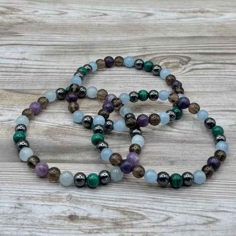 Pode incluir: Tr&ecirc;s pulseiras de contas com pedras de v&aacute;rias cores, incluindo ametista, &aacute;gua-marinha, quartzo fumado, malaquita e hematita.