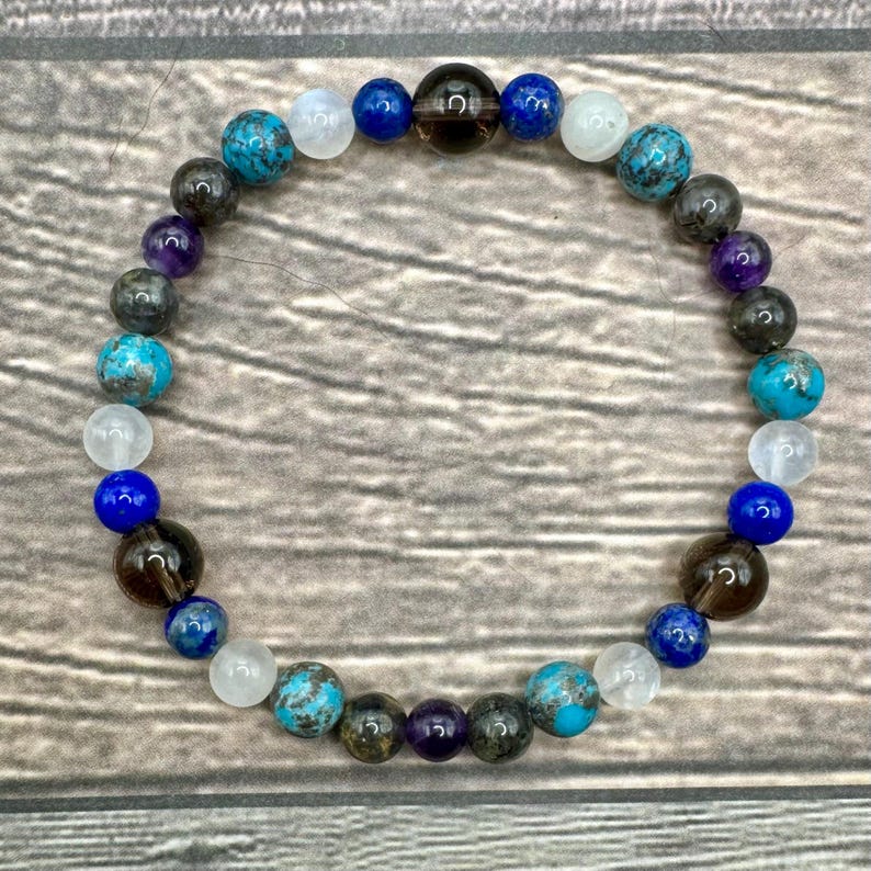 May include: A beaded bracelet featuring a range of stones, including turquoise, amethyst, smoky quartz, lapis lazuli, and white moonstone.