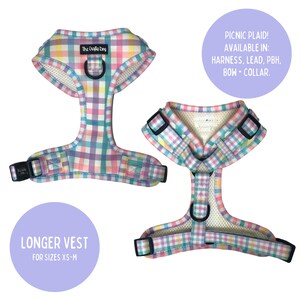 Op de afbeelding: Een roze, blauwe, gele en witte geruite hondenharnas met een mesh voering. Het harnas is verkrijgbaar in verschillende maten, waaronder XS-M. Het harnas is ook verkrijgbaar in een langere vest stijl. De tekst "The Crafly Dog" is op het harnas gedrukt. De tekst "PICNIC PLAID! AVAILABLE IN: HARNESS, LEAD, PBH, BOW + COLLAR." is gedrukt op een paarse cirkel. De tekst "LONGER VEST FOR SIZES XS-M" is gedrukt op een paarse cirkel.