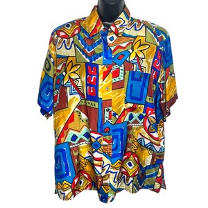 May include: A short-sleeved button-down shirt with a colorful geometric pattern in shades of blue, red, yellow, and brown.