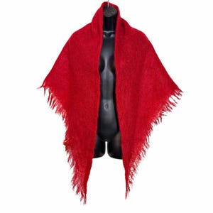 May include: A vibrant red triangular shawl featuring a soft, fuzzy, brushed texture throughout the fabric. The edges of the shawl are finished with long, delicate fringe detailing that hangs down along the sides of the garment.