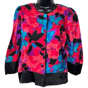 May include: A pink, blue, purple, and black floral print jacket with a black button closure and black trim.