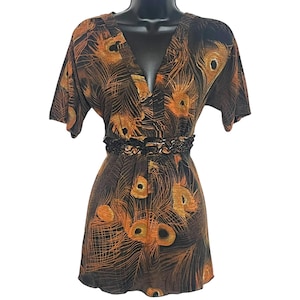 May include: A short-sleeved dress with a V-neckline and a black lace belt. The dress is made of a soft, flowing fabric and features a peacock feather print in shades of orange and brown.