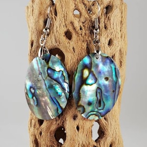 May include: A pair of iridescent abalone shell earrings with silver hooks. The shells are oval shaped and have a blue, green, and purple color.