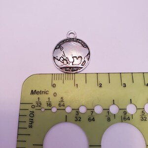 May include: A silver charm in the shape of a United States five-cent coin featuring a buffalo. The coin is approximately 1.9 cm in diameter.