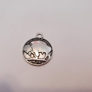 May include: Silver charm featuring a buffalo nickel design with the text "United States of America" and "Five Cents".