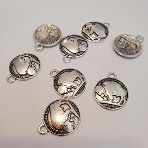 May include: A set of eight silver-toned metal charms featuring a design of a buffalo with the text "United States of America Five Cents".