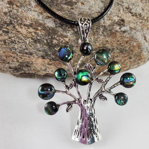 May include: A silver tree of life pendant necklace with iridescent abalone shell beads. The necklace is on a black cord.
