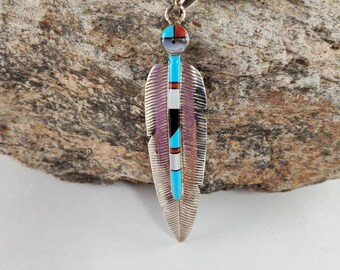Pendant of Kachina doll face with feather design.Feather pendant with inlay stones.  Southwestern feather pendant with kachina doll face.