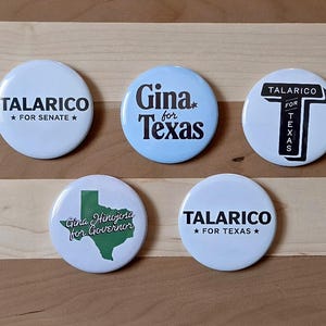 May include: Five circular political campaign buttons. One white button reads TALARICO FOR SENATE. One light blue button reads Gina for Texas. One white button features a large T with TALARICO FOR TEXAS. One white button shows a green Texas map with Gina Hinojosa for Governor. One white button reads TALARICO FOR TEXAS.