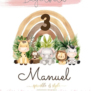 May include: A personalised iron-on transfer featuring a rainbow, the number 3, and jungle animals. The name Manuel is written below the rainbow. The text "sprinkle & style" is written below the name.