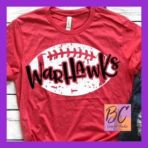 May include: Red t-shirt with a white football graphic and the text "WarHawks" in black.