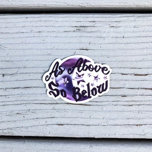 May include: A purple and white sticker with a crescent moon and stars. The text "As Above So Below" is written in a cursive font.