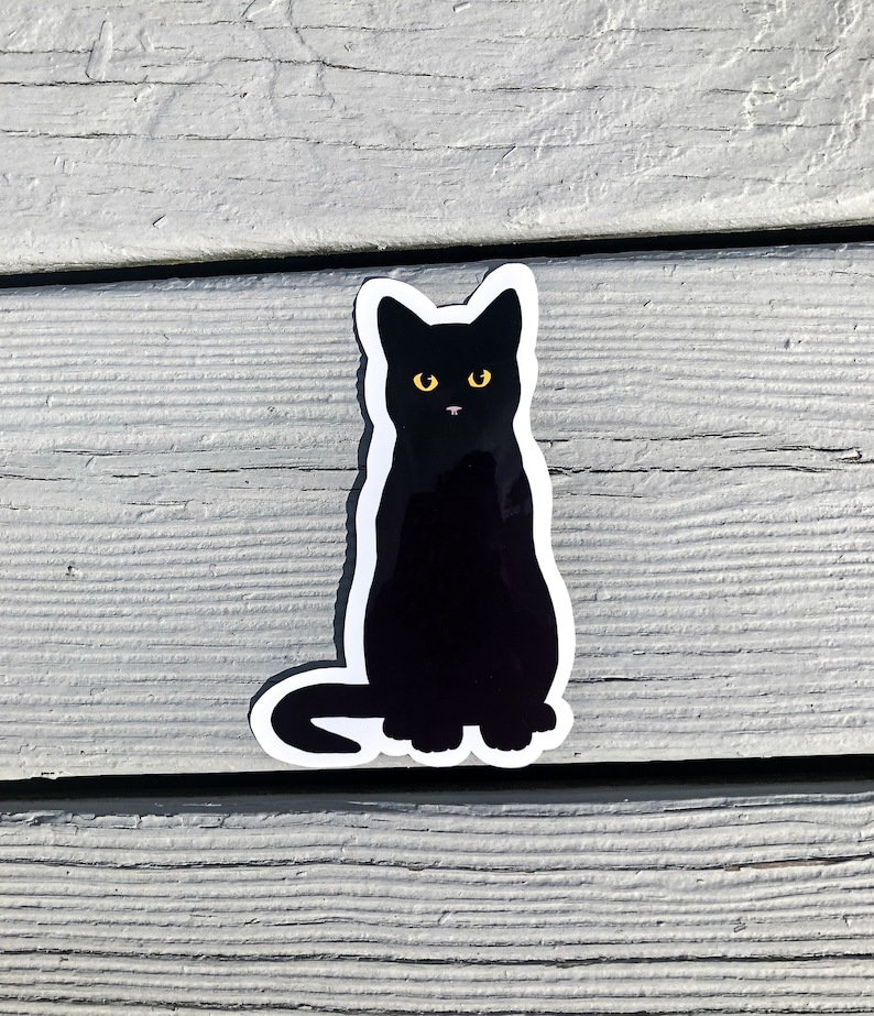 May include: Black cat sticker with yellow eyes. The cat is sitting upright with its tail curled around its legs.