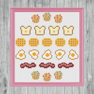May include: A cross-stitch pattern featuring a variety of breakfast foods, including toast, waffles, eggs, bacon, and muffins. The pattern is framed in a pink frame.