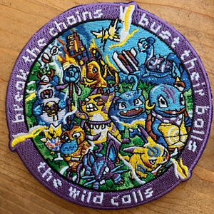 May include: A purple embroidered patch with a circle of colourful cartoon characters and the text "bust the chains, the wild calls".