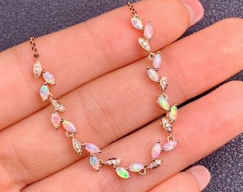 May include: A delicate gold necklace with a leaf design featuring iridescent opal stones and small clear diamonds.