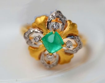 May include: A gold ring featuring a green gemstone and diamond accents. The ring has a floral design with intricate details.