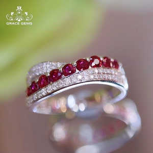 May include: A silver band ring with a row of red rubies and a row of smaller diamonds.