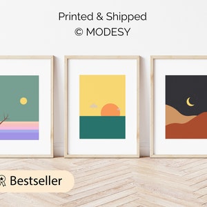 Könnte beinhalten: Drei gerahmte Kunstdrucke mit minimalistischen Landschaftsdesigns. Die Drucke zeigen einen Baum, eine Sonne und einen Mond über farbenfrohen Hintergründen. Der Text "Printed & Shipped" und "© MODESY" sind oben sichtbar. Das Wort "Bestseller" steht unten.