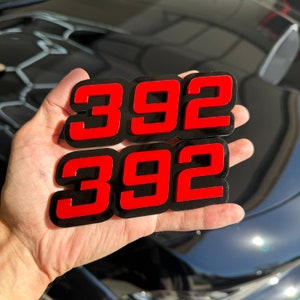 May include: Two black and red 392 number decals. The numbers are raised and have a glossy finish.