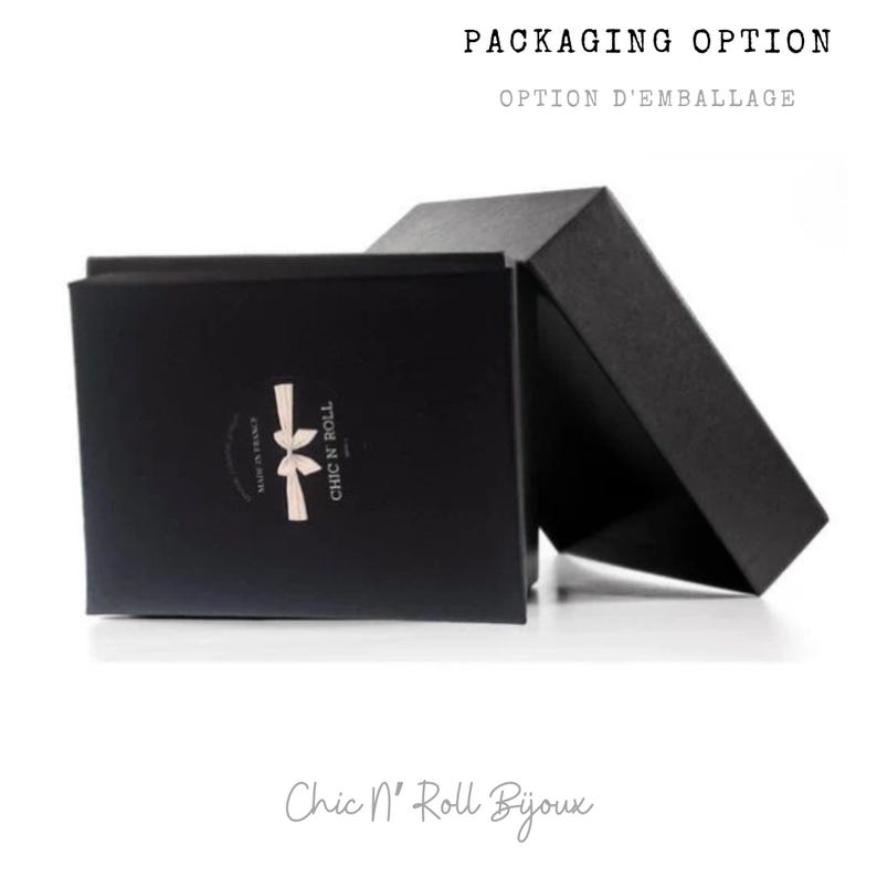 May include: Black gift box with a white ribbon and the text "Chic N' Roll" in white. The box is open and the lid is resting on top of the box.