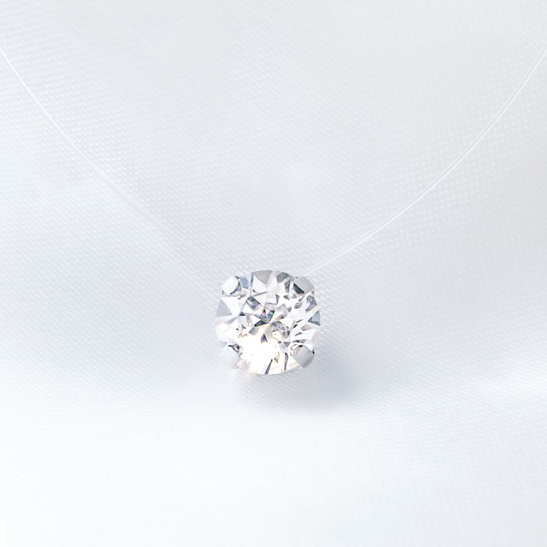 May include: A delicate, clear necklace with a single, sparkling, round diamond pendant.