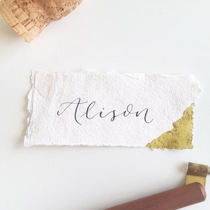 Placecards op handgemaakt gerecycled papier met bladgoud en moderne kalligrafie voor bruiloften en feesten