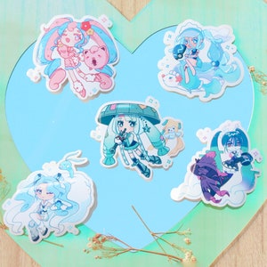 May include: Five colourful cartoon character stickers featuring anime-style girls with blue hair and various accessories. The stickers are on a light blue background with a heart-shaped outline.